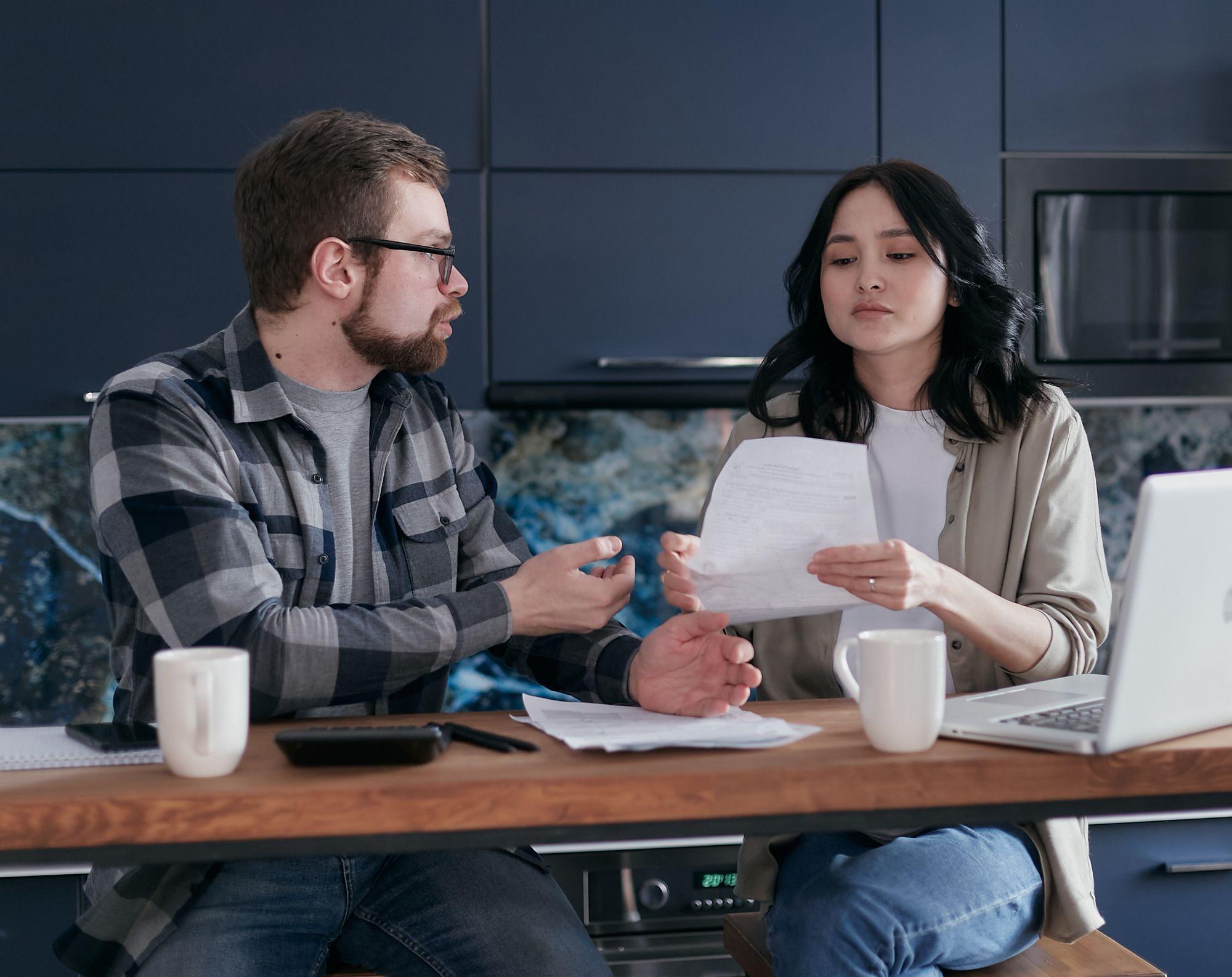 Un couple trie des papiers à la table de cuisine