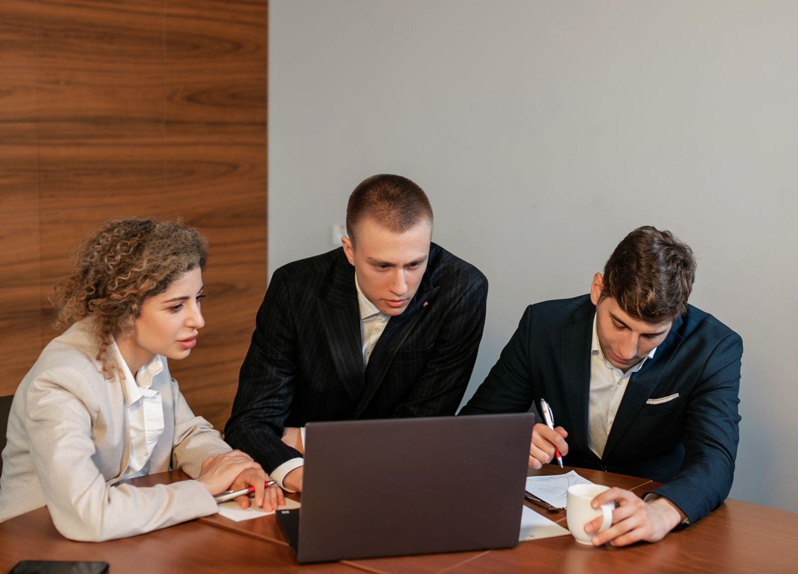 A team going over a document on a laptop