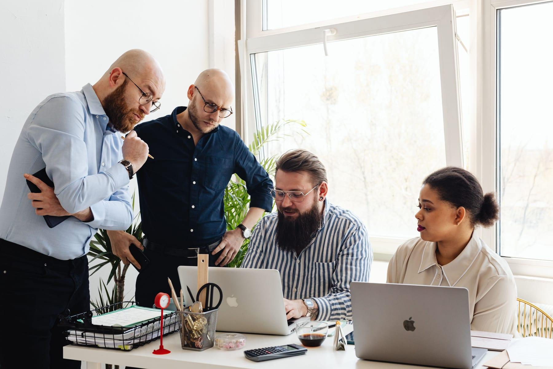 A team working together at a desk by a window