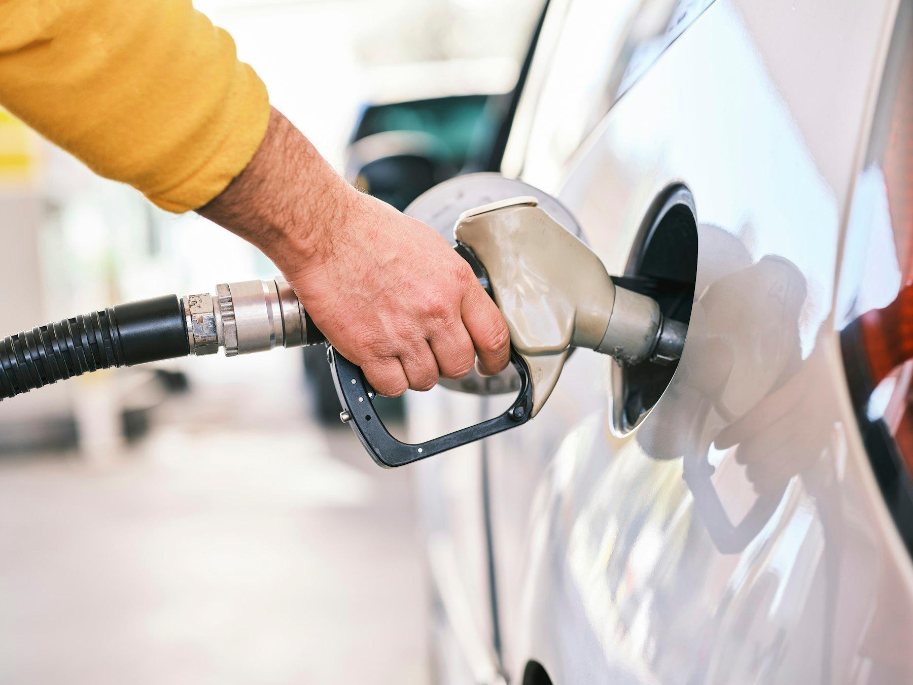 Filling up a white car at a gas station