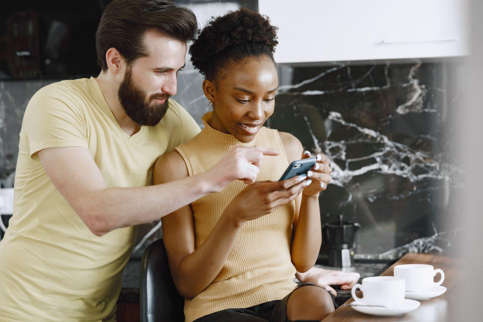 A couple looking at a phone together at home