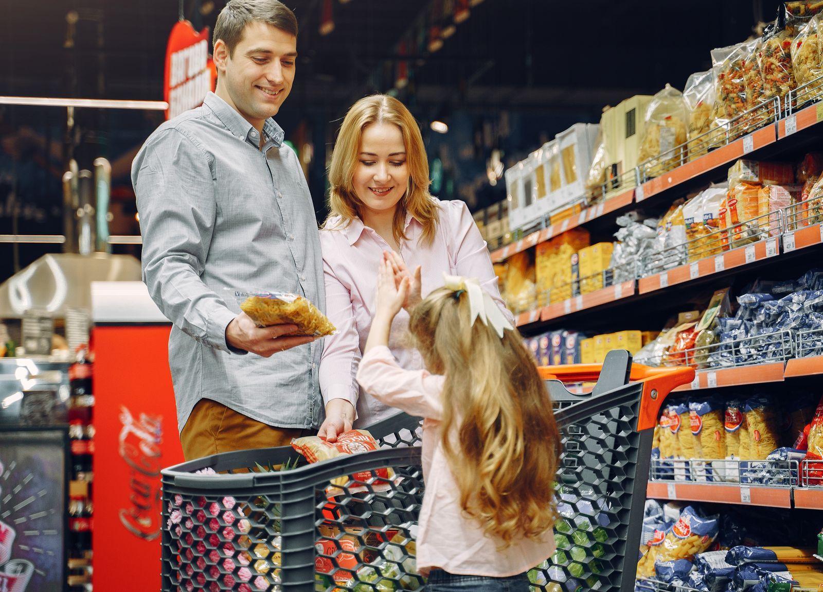 Parents and their daughter grocery shopping together