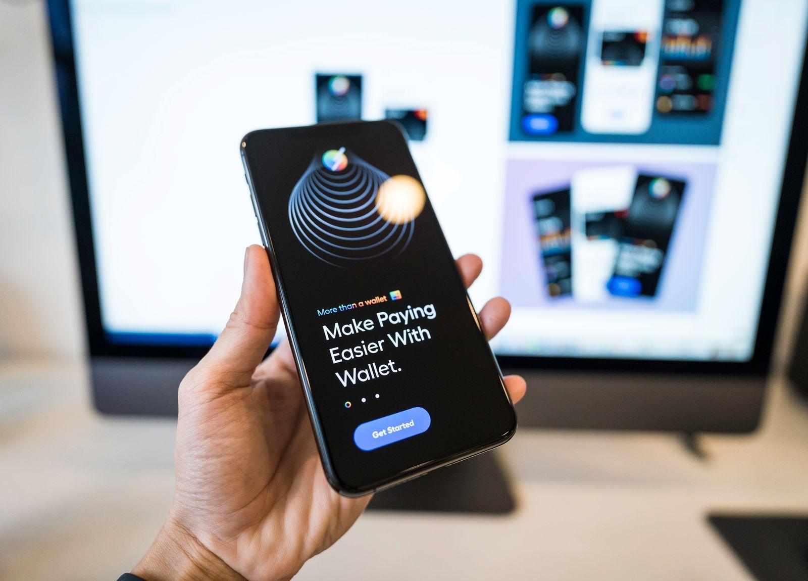 Une main qui tient un téléphone affichant une application de portefeuille numérique