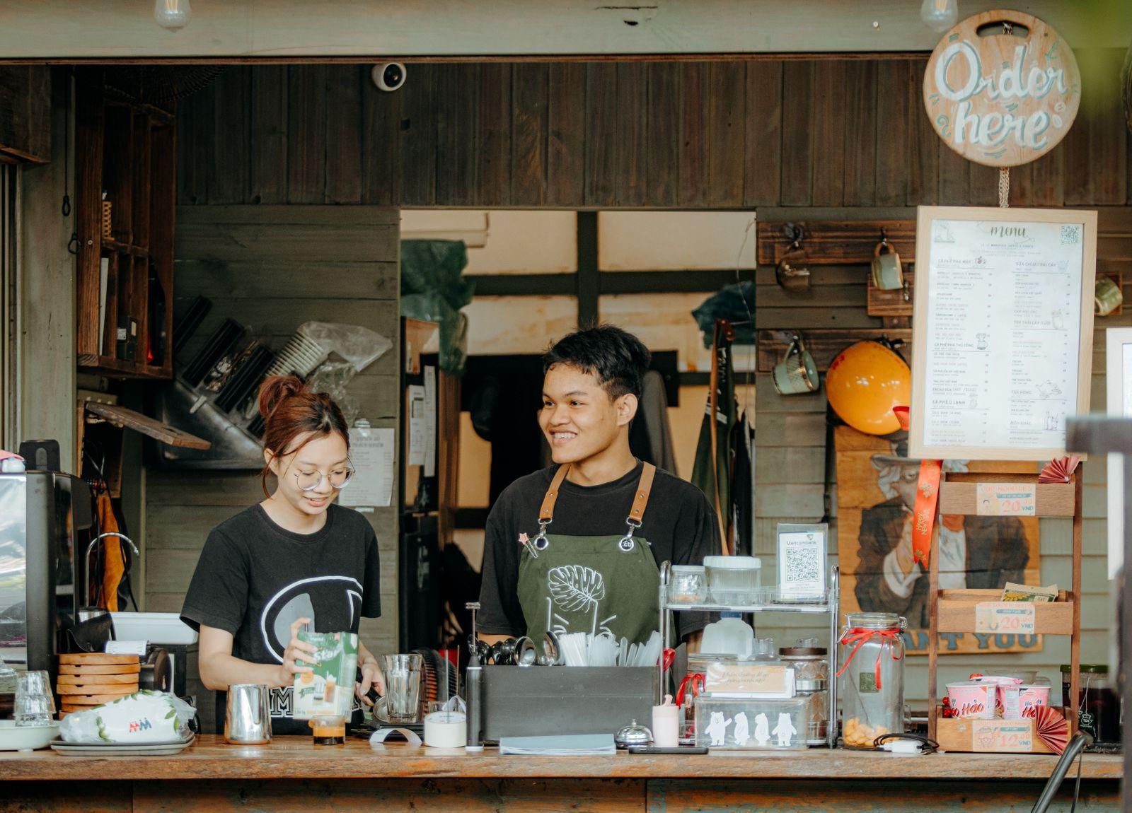 Des employés qui servent des clients derrière le comptoir d'un café