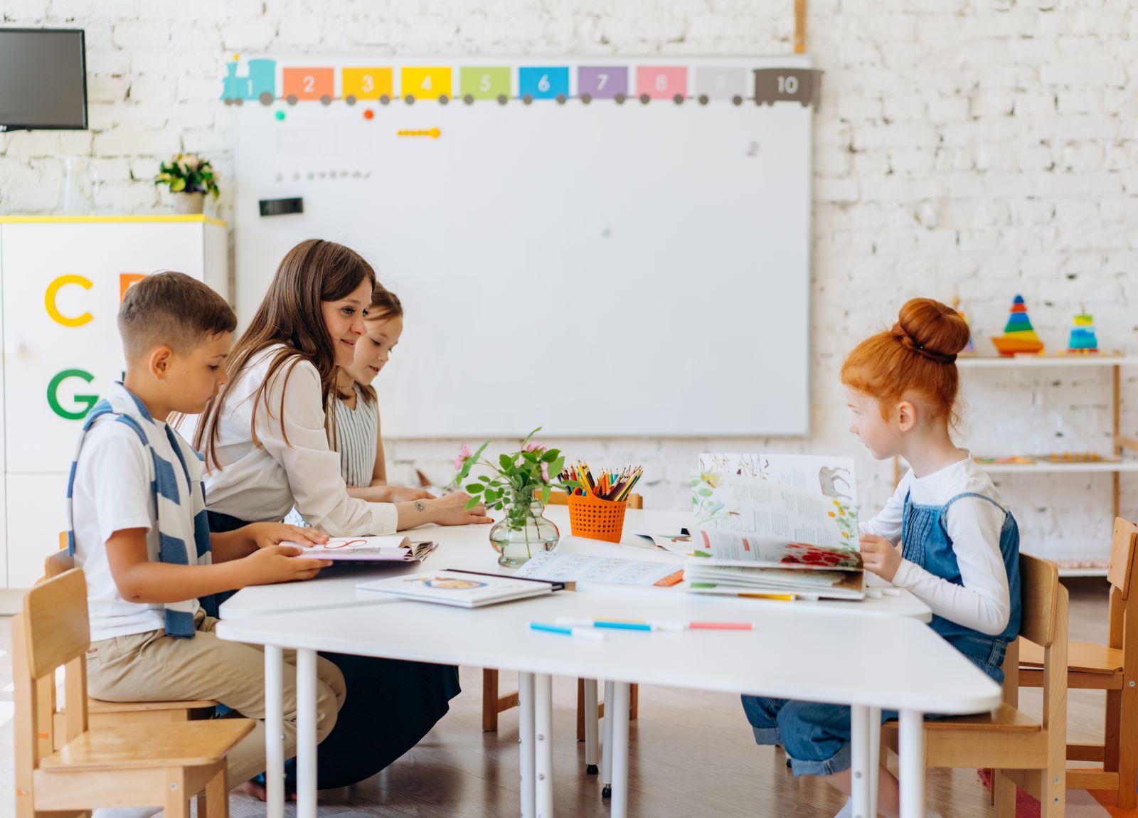 Une enseignante assise avec des élèves dans une classe