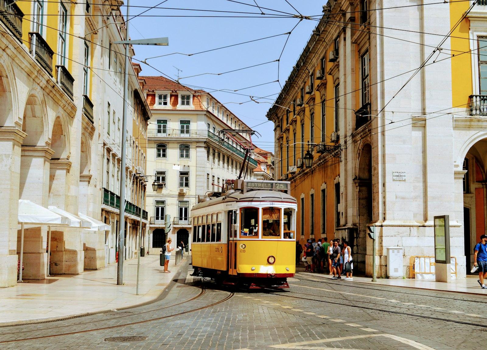A yellow tram on a street in Lisbon
